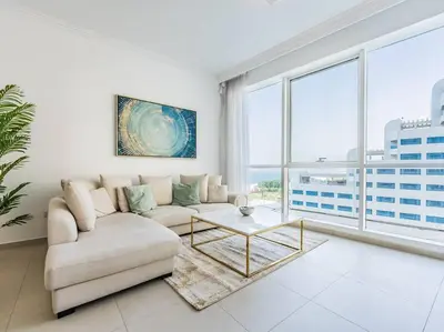 a living room with a couch and a table at Seaside Elegance-1BR-Al Bateen-Private Beach Access in Dubai