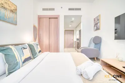 a bedroom with a large bed and a desk at Spacious Azizi Riviera Studio in Dubai