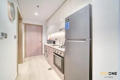 a kitchen with a stainless steel refrigerator at Spacious Azizi Riviera Studio in Dubai