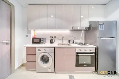a kitchen with a washing machine and a sink at Spacious Azizi Riviera Studio in Dubai