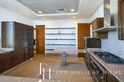 a kitchen with wooden cabinets and a table in it at LUX The Dream Palm Atlantis Sea View Suite in Dubai