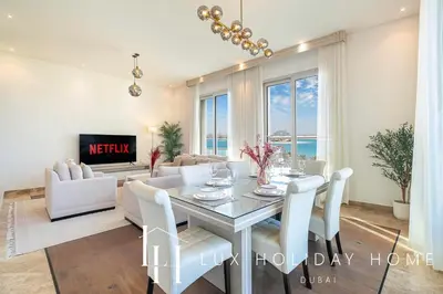 a living room with a table and chairs and a couch at LUX The Dream Palm Atlantis Sea View Suite in Dubai