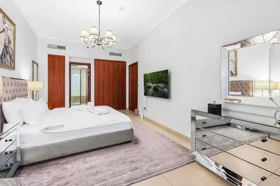 a white bedroom with a bed and a mirror at FIRST CLASS 2BR Stunning City Views in Dubai