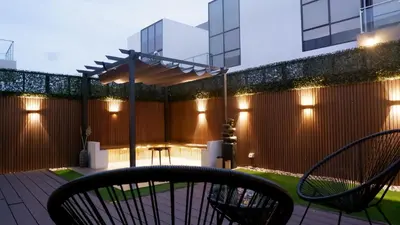 a patio with a table and chairs and a fence at Bliss at the Fields, 5BR Villa with Garden in Meydan in Dubai