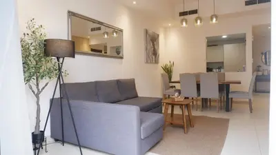a living room with a couch and a dining room at Bliss at the Fields, 5BR Villa with Garden in Meydan in Dubai