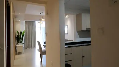 a kitchen with white cabinets and a dining room at Bliss at the Fields, 5BR Villa with Garden in Meydan in Dubai