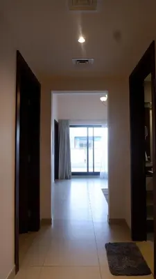 an empty room with a hallway with a large window at Bliss at the Fields, 5BR Villa with Garden in Meydan in Dubai