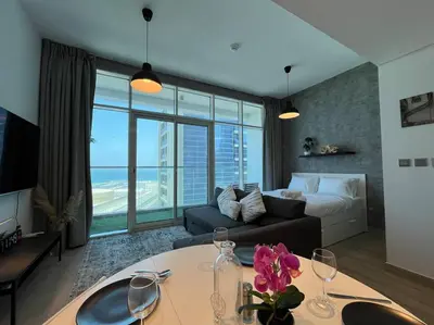 a living room with a couch and a table with wine glasses at Studio in Studio One Marina in Dubai