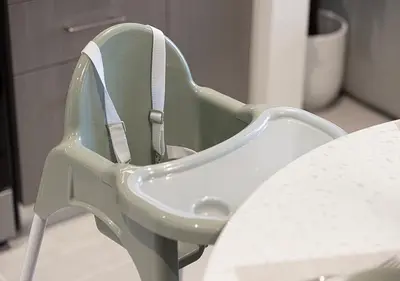 a green chair sitting next to a table at Kinfolk Homes - 5-Star Family Stay, 8 Minutes Walk to Dubai Mall & Burj Khalifa in Dubai