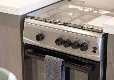 a stove top oven with a towel hanging on it at Kinfolk Homes - 5-Star Family Stay, 8 Minutes Walk to Dubai Mall & Burj Khalifa in Dubai