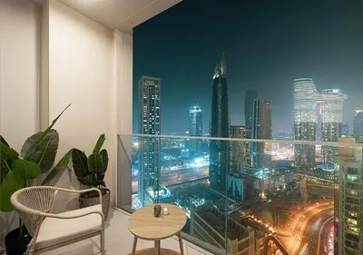 a room with a view of a city at night at Kinfolk Homes - 5-Star Family Stay, 8 Minutes Walk to Dubai Mall & Burj Khalifa in Dubai