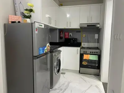 a kitchen with a refrigerator and a washing machine at Luxury & Comfort in Majan A Dubai Delight in Dubai