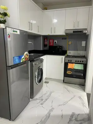 a kitchen with a washing machine and a stove at Luxury & Comfort in Majan A Dubai Delight in Dubai