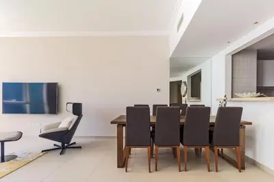 a dining room with a wooden table and black chairs at Luxury stay Private Beach Access in Dubai