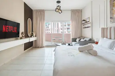 a hotel room with a bed and a tv at Sunny Studio Perfect For Discovery Gardens Stays in Dubai