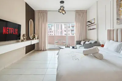 a hotel room with a bed and a tv at Sunny Studio Perfect For Discovery Gardens Stays in Dubai