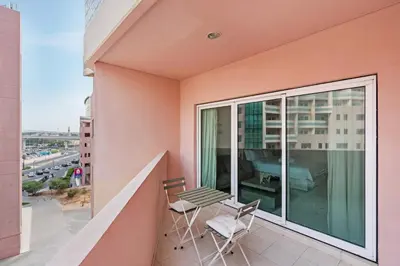 a balcony with a table and chairs on a building at Sunny Studio Perfect For Discovery Gardens Stays in Dubai