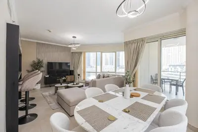 a living room with a table and chairs and a couch at Luxurious Waterfront at Al Majara Dubai Marina in Dubai