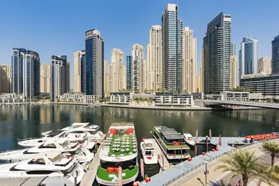 a group of boats docked in a river with a city at Luxurious Waterfront at Al Majara Dubai Marina in Dubai