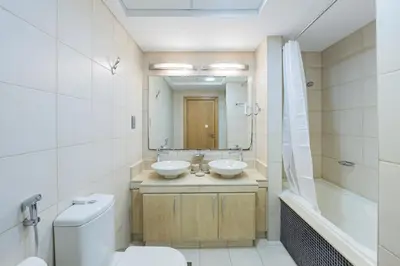 a bathroom with a toilet and a sink and a mirror at DVH Al Hamri Jumeirah Shoreline 2 Bed & Maids Free beach access in Dubai
