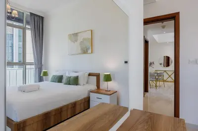 a bedroom with a white bed and a window at Vacationer I Sophisticated 1 Bedroom Apartment I Steps from Dubai Mall & Burj Khalifa I Dunya Tower in Dubai