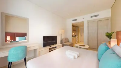 a living room with a couch and a table and a television at Seven Hotel and Apartment - Chic Studio in the Palm in Dubai