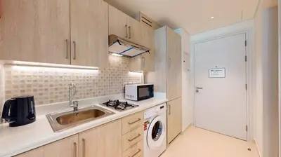 a kitchen with a sink and a washing machine at Seven Hotel and Apartment - Chic Studio in the Palm in Dubai
