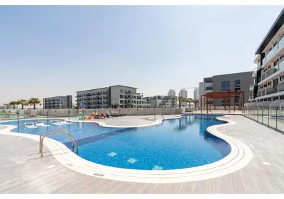 a large swimming pool in the middle of a building at Bright Resort Style Studio Amenities Samana GA by Vibel in Dubai