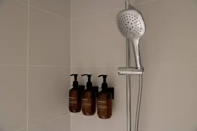 a shelf with four shampoo bottles in a bathroom at Elegant Luxury Living in Palace Residences in Dubai