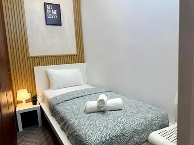 a bedroom with a bed with a towel on it at Canvas Partition Room in Barsha Heights Near Metro in Dubai