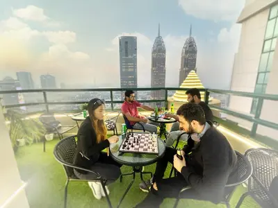 a group of people playing chess on the roof of a building at Canvas Partition Room in Barsha Heights Near Metro in Dubai