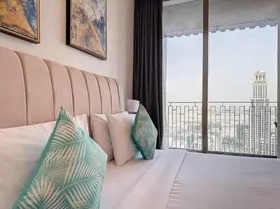 a bedroom with a bed with pillows and a large window at FAM Living - Spacious 3-Bedroom Apartment in Creek Gate with Stunning Views in Dubai