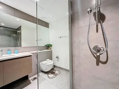 a bathroom with a shower and a toilet and a sink at FAM Living - Spacious 3-Bedroom Apartment in Creek Gate with Stunning Views in Dubai