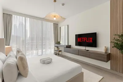 a hotel room with a tv and a bed at Superb 1Bed With Pool & Gym near the Burj Khalifa in Dubai
