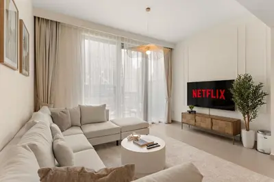 a white living room with a couch and a table at Superb 1Bed With Pool & Gym near the Burj Khalifa in Dubai
