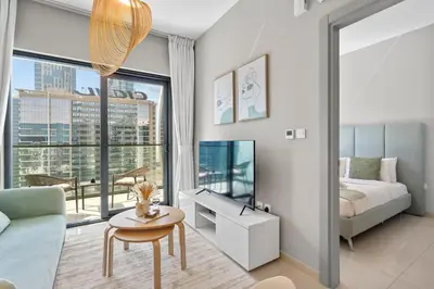 a living room with a bed and a large window at Superb 1BR Apartment in the Heart of Business Bay in Dubai