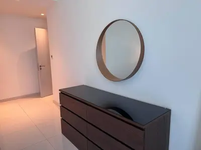a mirror on a wall above a dresser in a room at 2 Bed - Sunrise Bay Views in Dubai