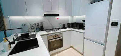 a kitchen with white cabinets and a stove top oven at Comfortable 1br Stay In Jvc Parking & Pool in Dubai