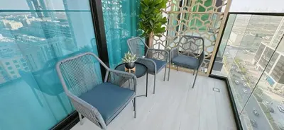 three chairs and a table on a balcony with a view at Comfortable 1br Stay In Jvc Parking & Pool in Dubai