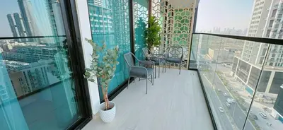 a balcony with chairs and a table on a building at Comfortable 1br Stay In Jvc Parking & Pool in Dubai