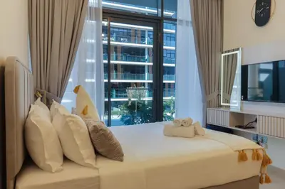 a bedroom with a large bed with a large window at Royalton - Serene Studio Apt in the Heart of Meydan District in Dubai