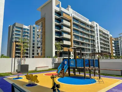a playground in front of a large apartment building at Royalton - Serene Studio Apt in the Heart of Meydan District in Dubai