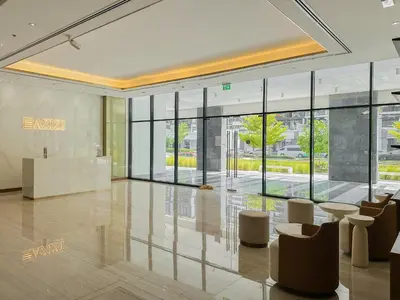 a lobby with tables and chairs and large windows at Royalton - Serene Studio Apt in the Heart of Meydan District in Dubai