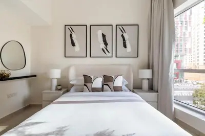a white bedroom with a bed and a window at GuestReady - Lux home amid Dubai Marina and JBR in Dubai