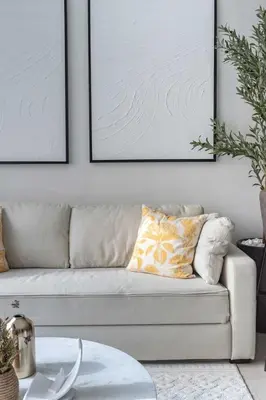 a living room with a couch and two pictures on the wall at GuestReady - Lux home amid Dubai Marina and JBR in Dubai