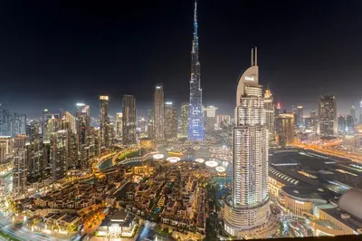 a night view of a large city with tall buildings at Full Fountain and Burj View - 3BR Burj Royale in Dubai