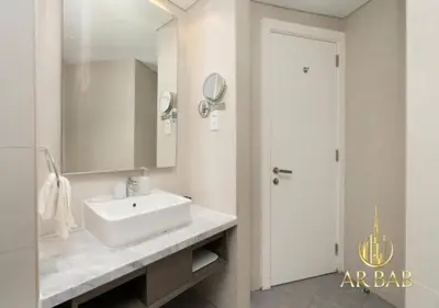 a white bathroom with a sink and a mirror at Damac Maison Prive - Luxury Studio - Burj Khalifa View in Dubai