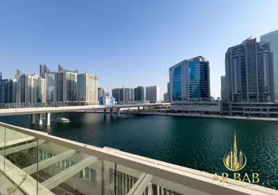 a bridge over a river in a city with tall buildings at Damac Maison Prive - Luxury Studio - Burj Khalifa View in Dubai