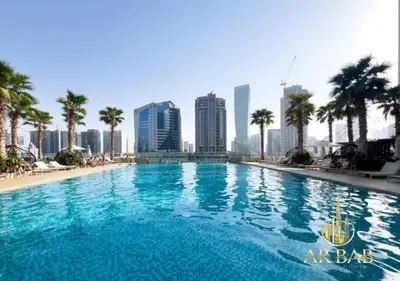 a large swimming pool with a city skyline in the background at Damac Maison Prive - Luxury Studio - Burj Khalifa View in Dubai