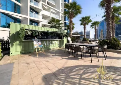 a patio with a table and chairs in front of a building at Damac Maison Prive - Luxury Studio - Burj Khalifa View in Dubai